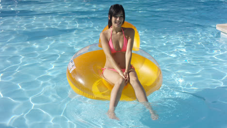 Lovely-young-woman-floating-in-a-swimming-pool
