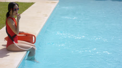Rettungsschwimmer-Benutzt-Pfeife,-Während-Er-Im-Pool-Sitzt