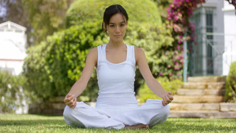 Mujer-Joven-Sentada-Meditando-En-Un-Jardín.