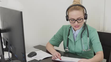 Female-doctor-reading-document-during-video-call