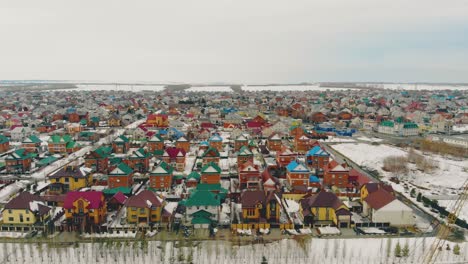 cottage-complex-with-multicolored-houses-against-snowy-field