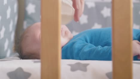 Mama-Füttert-Kleines-Baby-Im-Azurblauen-Anzug-Mit-Frischer-Milch-Im-Kinderbett