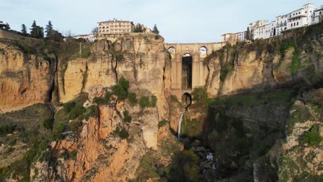 Ronda-Bogenbrücke,-Wasserfall-Und-Stadtbild-In-Malaga,-Andalusien,-Spanien---Luftaufnahme