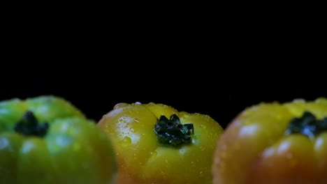 Drops-of-water-splash-on-heirloom-tomatoes-in-black-background
