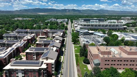 College-campus-dorms-and-apartments-with-solar-panels-on-roofs-with-university-stadium