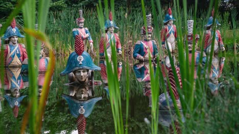 Decaying-statues-of-Napoleon-and-soldiers-in-swamp-terrain,-abandoned-theme-park