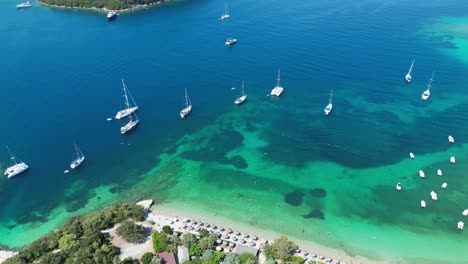 Boats,-Coastline-and-Green-Island-at-Syvota,-Epirus,-Greece---Aerial-Reveal