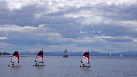 Vier-Kleine-Segelboote-Mit-Einem-Leuchtturm-Im-Hintergrund