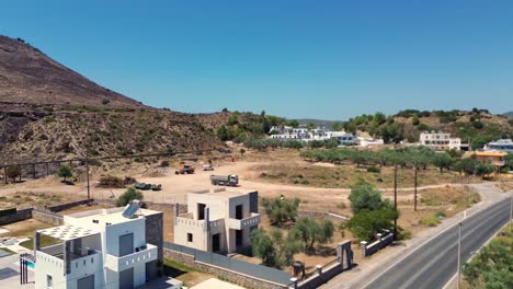 Over-the-road-and-green-Forest-in-Rhodes-with-seaside-in-the-background-in-Greece-during-the-summer-filmed-with-the-drone-in-4K