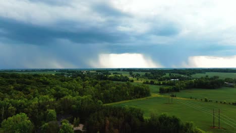 descending-aerial-Appleton,-Wisconsin-lush-green-farmland-with-large-storm-cloud-on-the-horizon