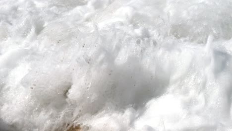 Close-up-of-foamy-waves-crashing-against-rocks-on-Corfu-Island