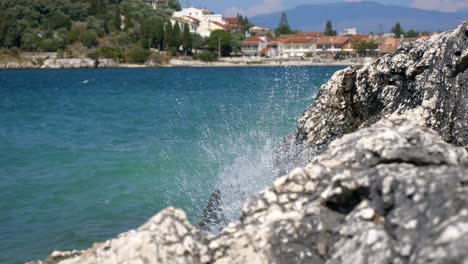 Close-up-on-foamy-waves-of-the-Ionian-Sea-crashing-against-a-rocky-cliff-on-Corfu-Island