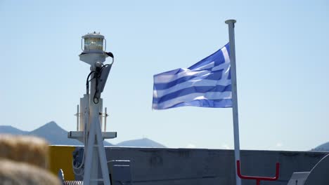 Greek-flag-hoisted-on-the-mast,-fluttering-in-the-wind