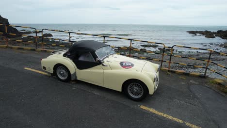 Classic-nineteen-fifties-English-sportscar-parked-on-a-local-beauty-spot-on-The-Copper-Coast-Drive-Waterford-Ireland-on-a-summer-day