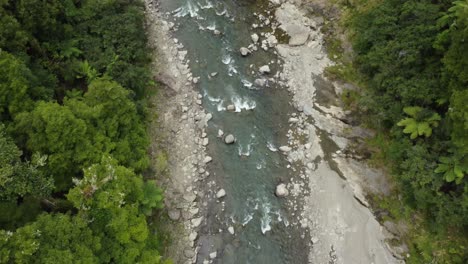 Aerial-view-above-pristine-forest-river-flowing-over-rapids