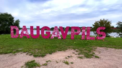 Daugavpils-tourist-pink-promotion-letters-near-the-Daugava-river