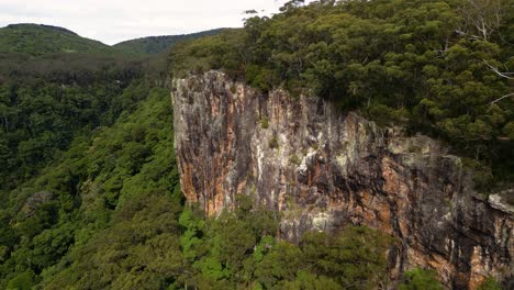 Aerial-over-cliff-face-on-the-Twin-Falls-walk,-Springbrook-National-Park,-Gold-Coast-Hinterland,-Queensland,-Australia