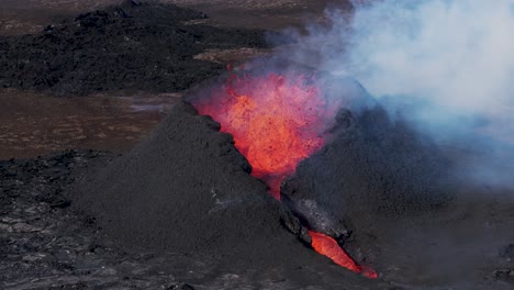 Powerful-volcano-eruption-with-lava-flowing-out-of-crater,-aerial