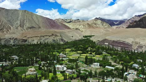 Aerial-camera-moving-above-to-city-of-leh,-Leh-Ladakh,-beautiful-Landscape-view-on-road-around-with-mountain-and-sky-background,-Leh,-Ladakh,-Jammu-and-Kashmir,-India