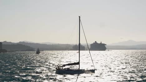 A-sailing-boat-navigating-through-the-turbulent-Greek-waters-of-the-Ionian-Sea-near-Corfu-Island,-towing-a-pontoon