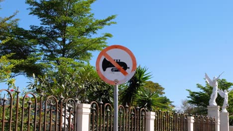 No-music-warning-sign-post-for-noise-control-outside-a-church-in-capital-city-Dili,-Timor-Leste,-Southeast-Asia