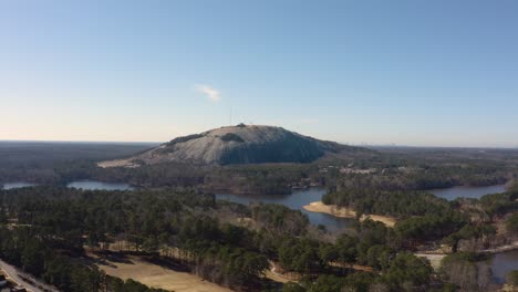 Aerial-drone-shot-slowly-rotating-counter-clockwise-around-the-NW-side-of-Stone-Mountain-in-Stone-Mountain-Park-near-Atlanta-with-the-Confederate-Memorial-in-the-shadows