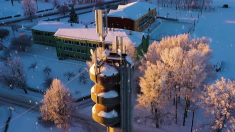 Cell-antenna-on-old-tower-in-small-rural-town,-snowing