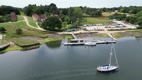Small-Yacht-passing-Bucklers-hard-Hampshire-Historic-ship-building-Village-UK-aerial