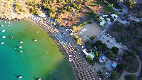 Playa-De-Agios-Pavlos-En-Rodas,-Grecia-Con-La-Acrópolis-De-Lindos,-Casas-Y-El-Mar-Mediterráneo-Durante-El-Día-Filmado-Con-El-Drone