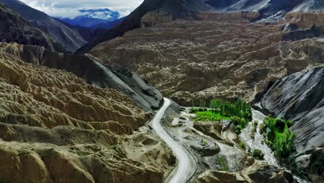 Cámara-Aérea-De-Drones-Que-Pasa-Por-Delante-De-La-Carretera-De-Leh-Hills,-Un-Lugar-Muy-Alto-Y-Muy-Difícil-De-Transportar-Detrás-De-Montañas-Visibles-Del-Himalaya-Nublado-Por-Nubes