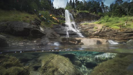 Ein-Beruhigendes-Video-Präsentiert-Die-Naturwunder-Eines-Flusses-Mit-Klarem-Wasser-Und-Einem-Entfernten-Wasserfall
