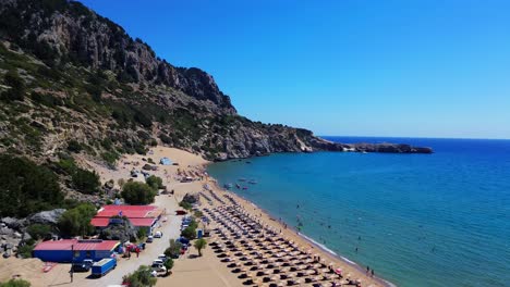 Tsambika-beach-in-Faliraki,-Rhodes-in-Greece-filmed-with-the-drone-from-above-with-Mediterranean-Sea-in-the-summer-holiday