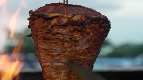 Mexican-latin-taquero-spinning-the-trompo-of-Carne-al-pastor-asada-beef-pork-in-a-mexico-restaurant-cantina-and-preparing-taco