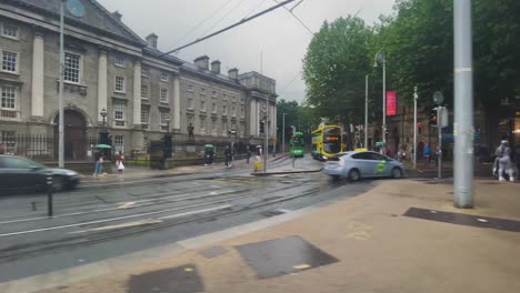 Una-Toma-En-Movimiento-De-4k-Que-Pasa-Por-Trinity-College-En-College-Green-Dublin-En-Autobús-Mientras-Los-Autobuses-De-Dublín-Pasan-Por-College-Green