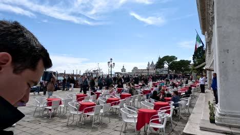 Menschen,-Die-Ihren-Tag-An-Der-Uferpromenade-Vor-Dem-Caffè-Gelateria-Al-Todaro-Dal-1948-In-Venedig,-Italien,-Verbringen