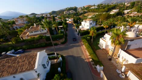Scenic-FPV-aerial-following-a-Porsche-driving-along-a-picturesque-road-in-Marbella,-Spain
