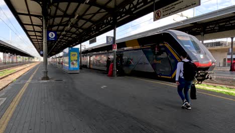 Un-Grupo-De-Pasajeros-Tardíos-Corriendo-Hacia-Un-Tren-Eléctrico-De-Alta-Velocidad-En-Una-Plataforma-En-La-Estación-Central-De-Tren-De-Bolonia,-Italia