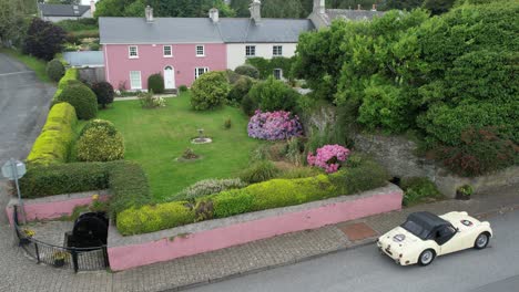 Classic-sportscar-parked-in-a-tourist-village-on-a-road-trip-in-Stradbally-Village-on-The-Copper-Coast-Drive-in-Waterford-Ireland-on-a-warm-summer-Morning