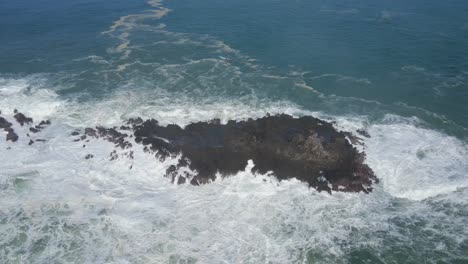 Ocean-waves-hitting-rocky-island,-power-of-sea,-aerial-orbit-view