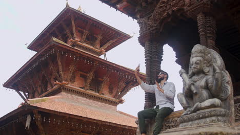 A-man-showing-famous-Patan-Durbar-Square-Heritage-of-Nepal-in-a-video-call-sitting-and-appreciating-the-architectural-beauty