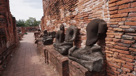 Fila-De-Estatuas-De-Buda-Sin-Cabeza-En-El-Templo-Wat-Mahathat-En-Ayutthaya,-Tailandia
