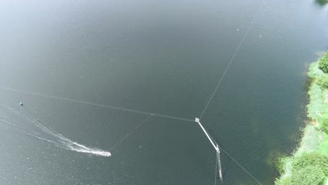 Aerial-drone-shot-moving-with-wakeboarding-person-at-a-lake