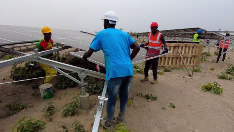 Solar-Power-Energy-With-Engineers-And-Technicians-Installing-Photovoltaic-Panel-At-Solar-Farm-In-Jambur,-Gambia-West-Africa