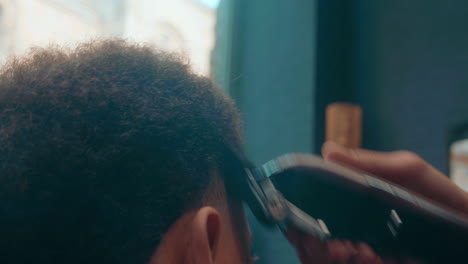 Erstaunliche-Nahaufnahme-In-Zeitlupe-Eines-Afrohaarigen-Jungen-Mannes,-Der-Sich-Von-Einem-Professionellen-Friseur-Die-Haare-Mit-Einem-Rasiermesser-Schneiden-Lässt