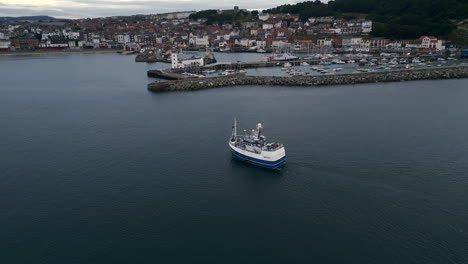 Establishing-Drone-Shot-of-Scarborough-Harbour-with-Fishing-Boat-Heading-Inland