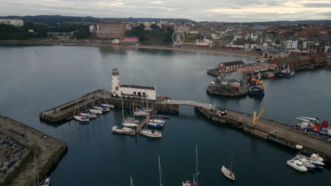 Establishing-Drone-Shot-Over-Scarborough-Harbour-and-Around-Lighthouse-at-Sunrise