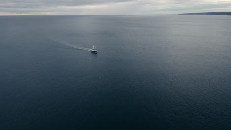 Drone-Shot-of-Fishing-Boat-Heading-Inland-Towards-Scarborough