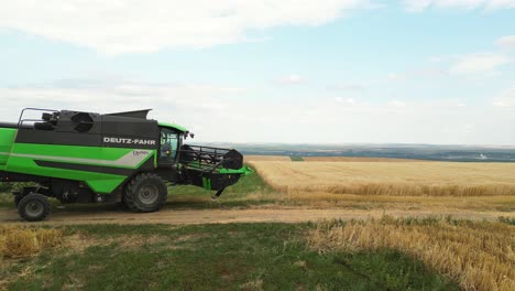 large-green-harvest-combine-driving-over-a-field-to-start-harvesting