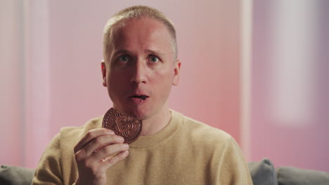 Shocked-man-eats-chocolate-cookies-with-sign-of-bitcoin