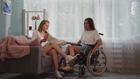 Blonde-woman-helps-disabled-girlfriend-to-move-in-wheelchair